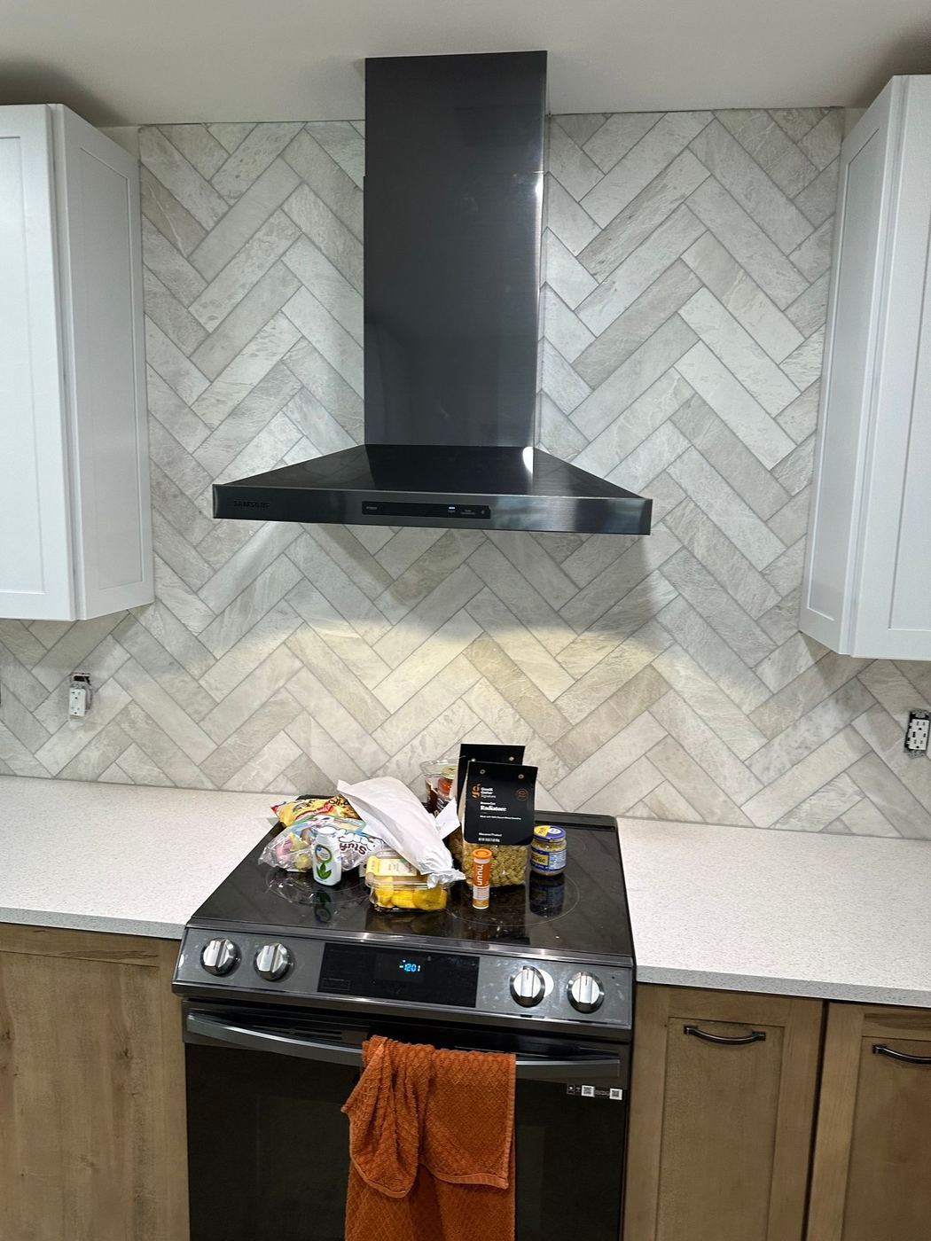 Range wall: Herringbone backsplash and black hood
